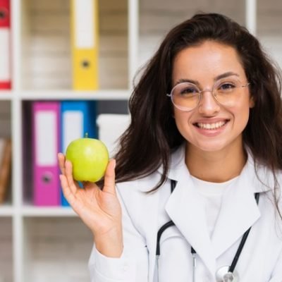 front-view-smiley-doctor-with-apple_23-2148302118